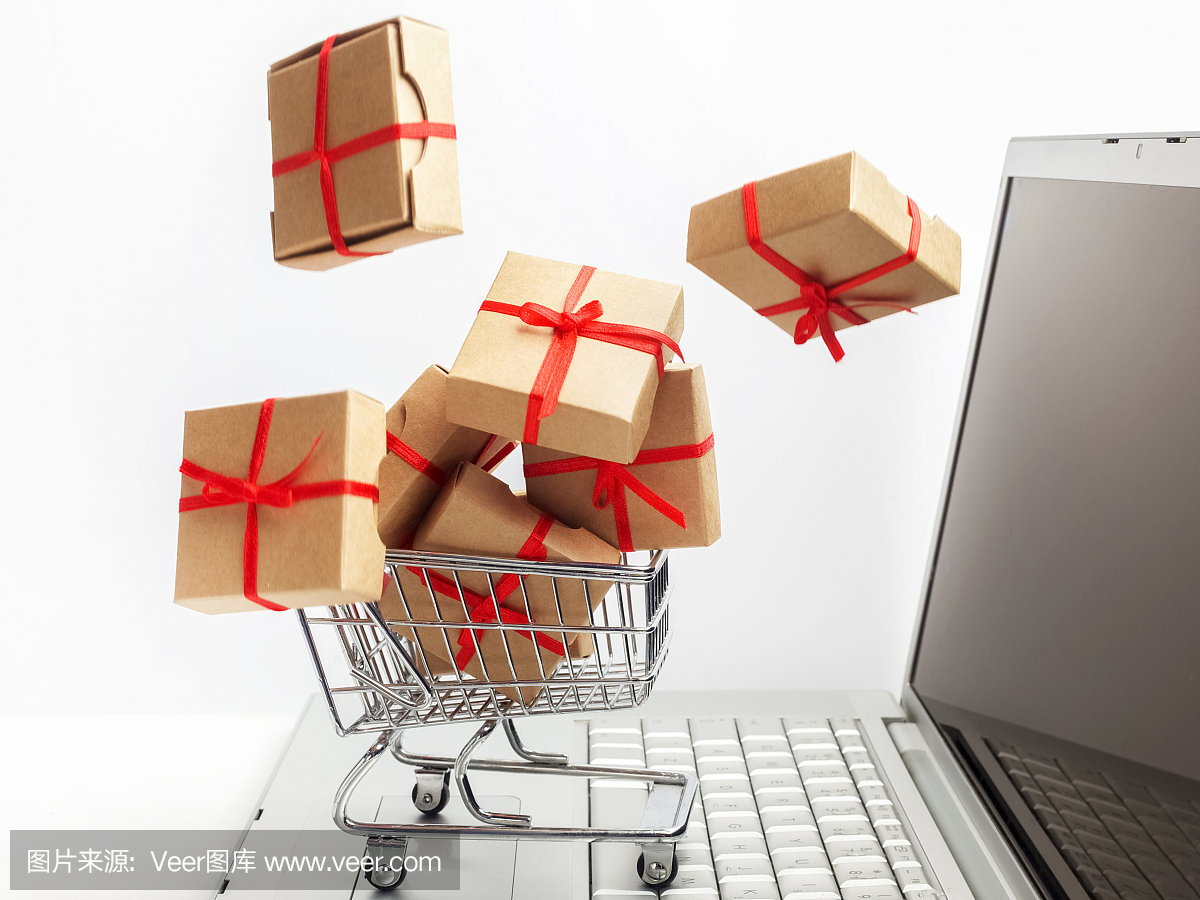 购物车里的纸盒放在笔记本键盘上。关于电子商务的想法,网上购买或销售商品或服务的交易。